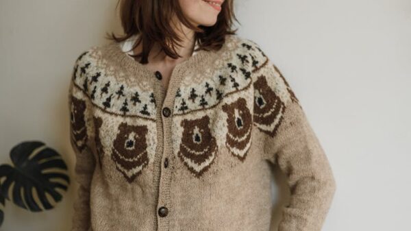 A woman in a knitted sweater poses indoors, conveying warmth and style.