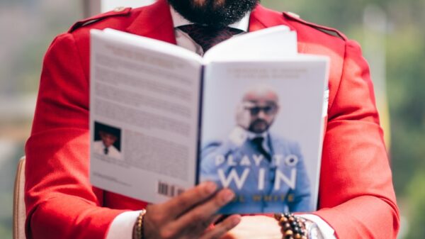 man in red long sleeve shirt holding white book