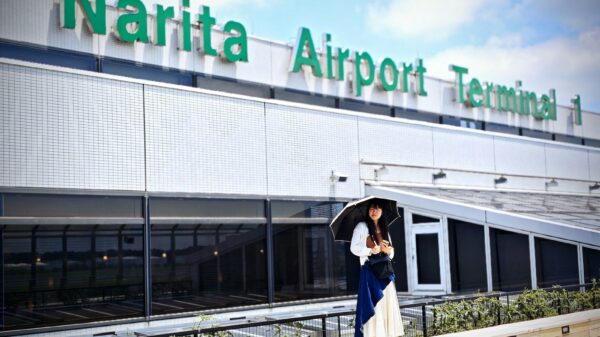 A woman holding an umbrella standing in front of a building