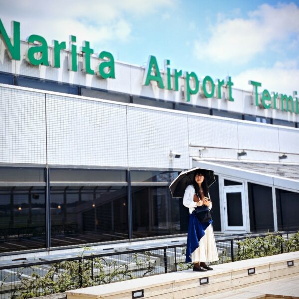 A woman holding an umbrella standing in front of a building