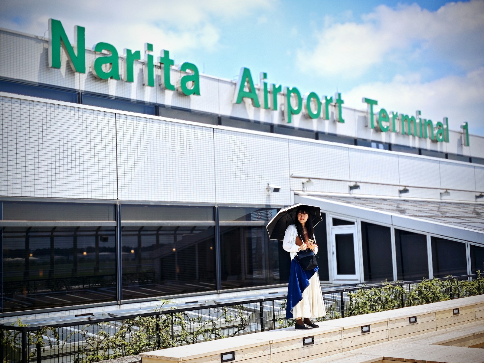 A woman holding an umbrella standing in front of a building
