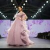 Elegant model in lavender gown showcases high fashion on runway during Indian fashion week event.