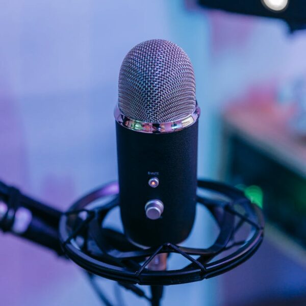 A detailed view of a condenser microphone with pop filter in a modern music studio.