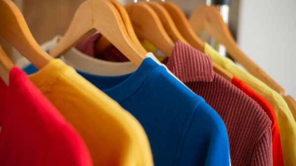 Vibrant clothing displayed on wooden hangers, showcasing fashion and color variety.