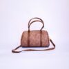 Stylish brown leather handbag with handles and strap on a white backdrop.
