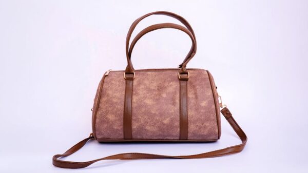 Stylish brown leather handbag with handles and strap on a white backdrop.
