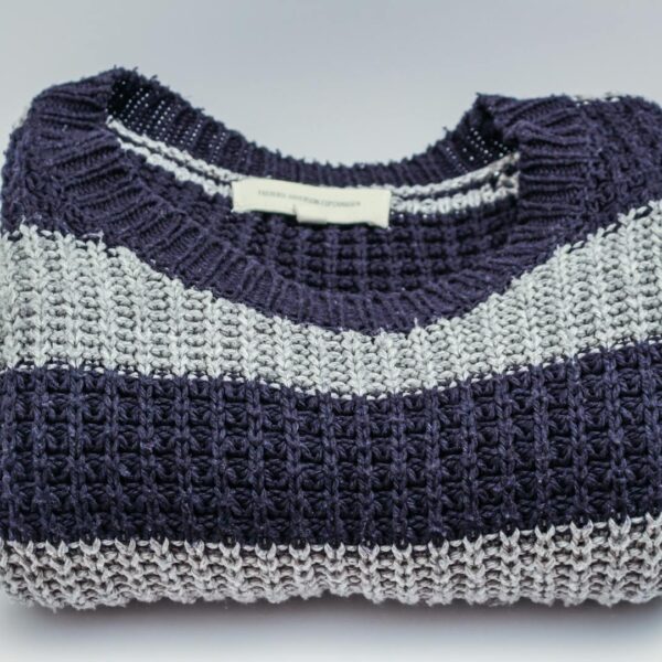 Warm knitted sweater with blue and white stripes, perfect for winter fashion.