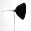 Black and silver Jinbei studio lighting umbrella on a stand for professional photography.
