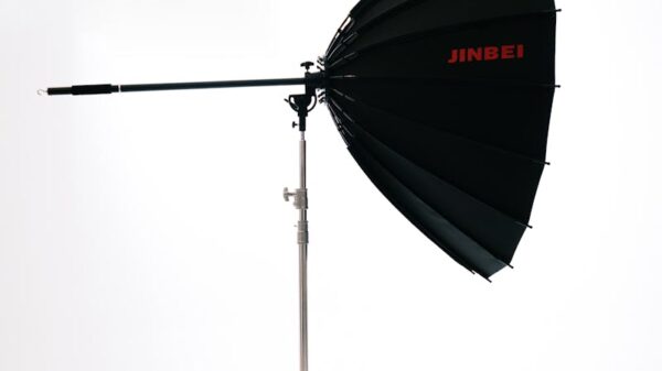 Black and silver Jinbei studio lighting umbrella on a stand for professional photography.