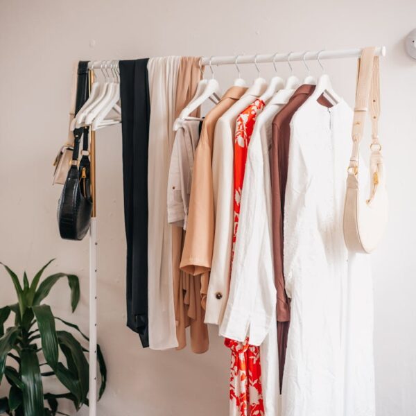 Stylish clothing rack with dresses and accessories in a boutique interior.