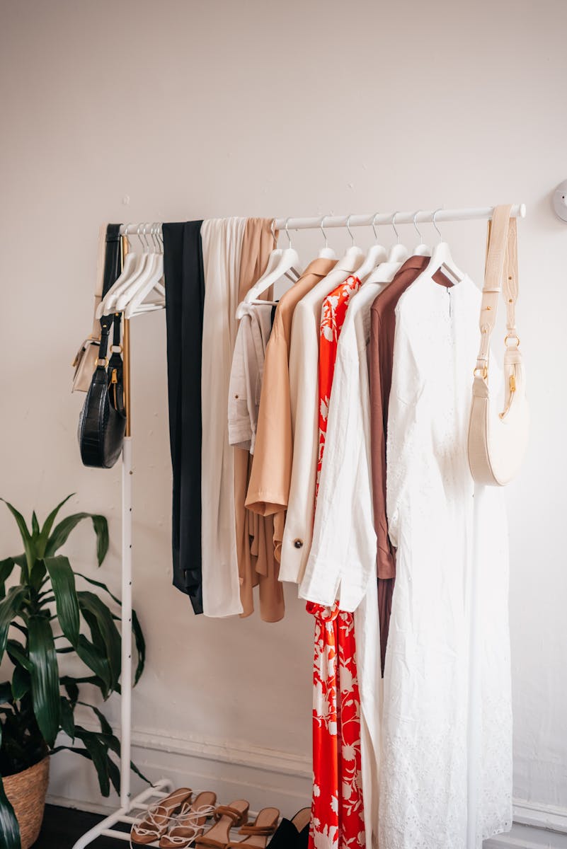 Stylish clothing rack with dresses and accessories in a boutique interior.