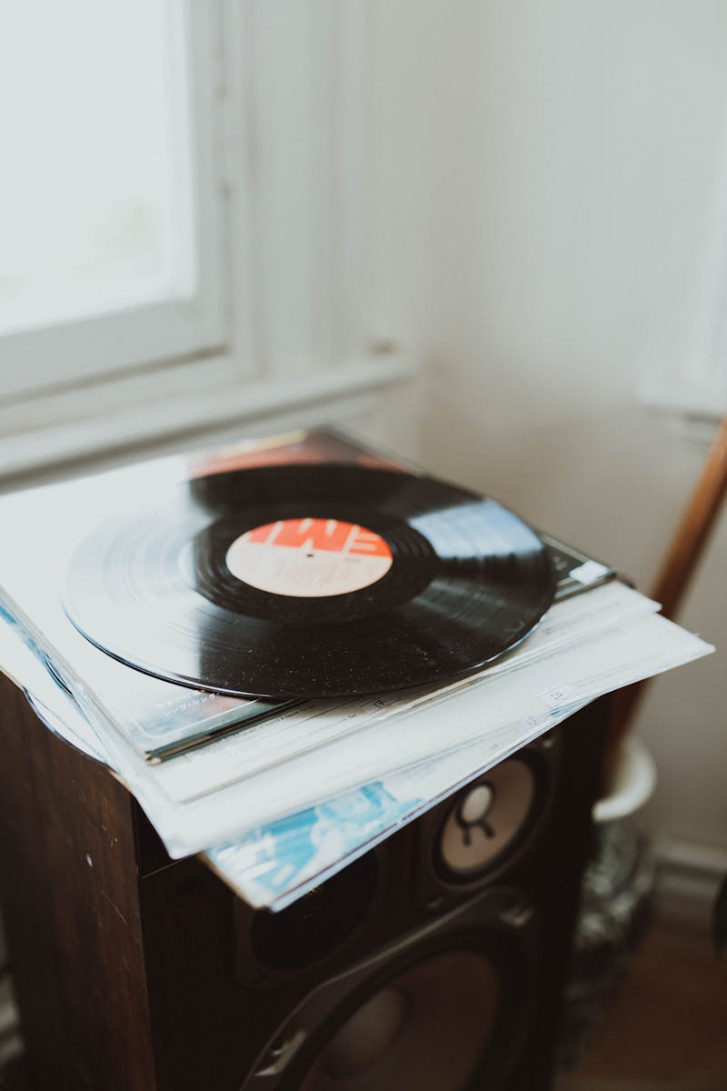 A vinyl record rests on a speaker, creating a nostalgic music atmosphere indoors.