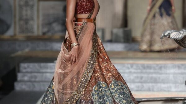 Model showcasing a traditional Indian lehenga on the runway at India Couture Week in New Delhi.
