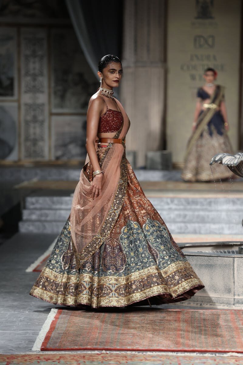 Model showcasing a traditional Indian lehenga on the runway at India Couture Week in New Delhi.