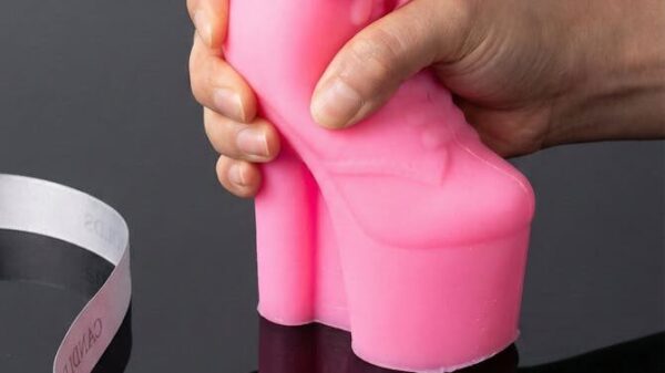 Pink high heel silicone candle mold held by hand on black table in New York. Perfect for creative candle making.