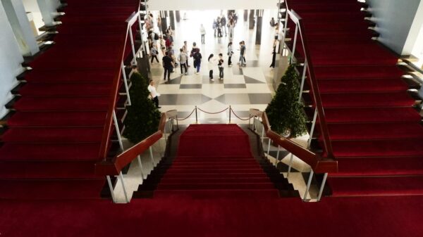 Elegant red-carpeted staircase inside a historic Vietnamese building.