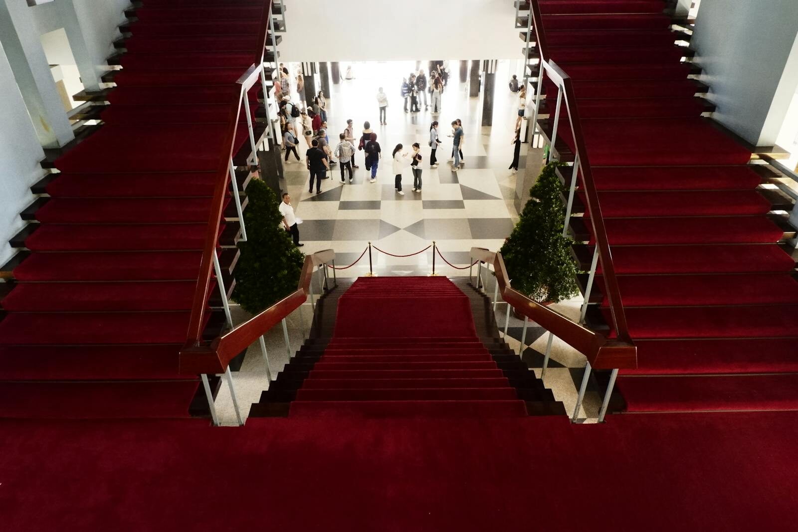 Elegant red-carpeted staircase inside a historic Vietnamese building.
