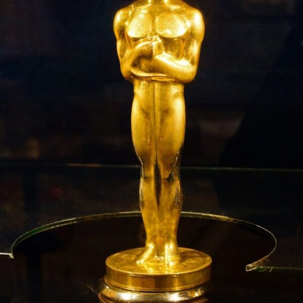 An oscar statue on display in a glass case
