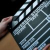 A detailed view of a Universal Studios clapboard held in hands, perfect for film industry concepts.