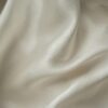 Close-up of smooth white silk fabric with soft folds and gentle draping.