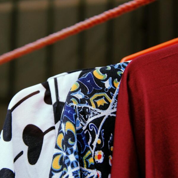 Close-up of vibrant modern fashion garments hanging on a rack.