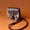 Chic leather sling bag with brown texture, perfect for stylish fashion statements.