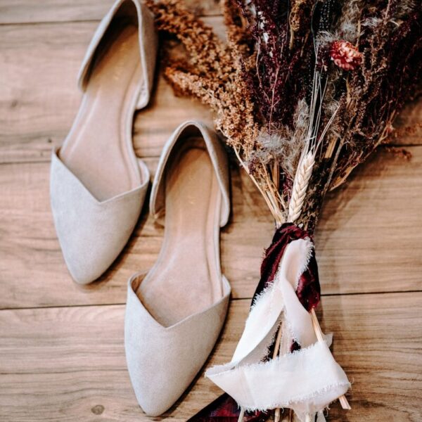 pair of shoes beside flowers