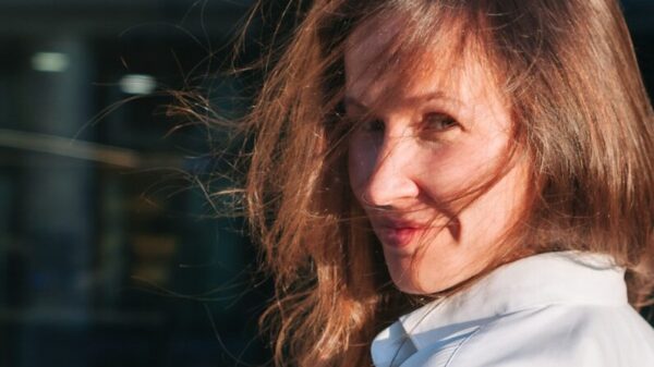 a woman in a white shirt is smiling at the camera