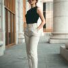 a woman in a black top and white pants