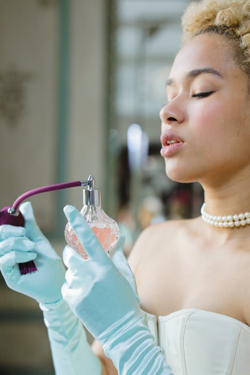 Elegant woman in vintage attire with a classic perfume bottle.
