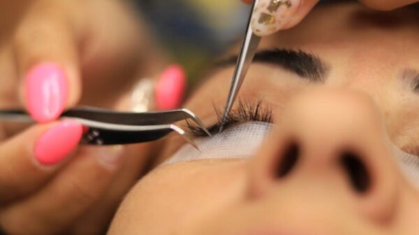 Detailed close-up of an eyelash extension application in a beauty salon.