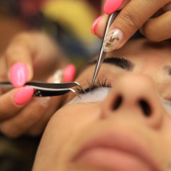 Detailed close-up of an eyelash extension application in a beauty salon.
