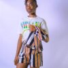 Teenage model poses confidently in a stylish striped ensemble against a white backdrop, exuding modern fashion vibes.