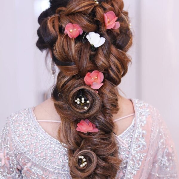 Stunning elegant braid adorned with pink and white flowers, perfect for bridal looks.