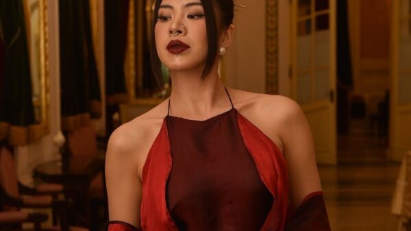 Portrait of an elegant woman in a luxurious and ornately decorated interior with warm lighting.