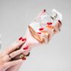 person holding clear glass bottle