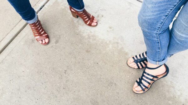 two woman wearing black and brown strappy sandals