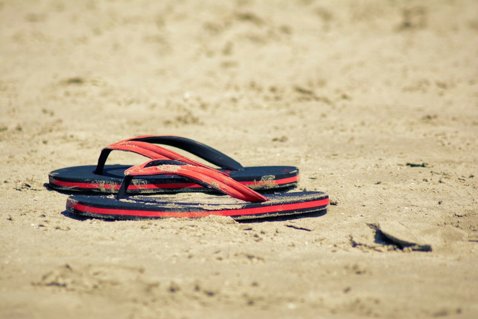 Flip-flops resting on a sandy beach