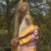 Blonde woman in stylish jacket in nature