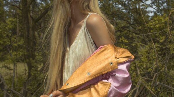 Blonde woman in stylish jacket in nature