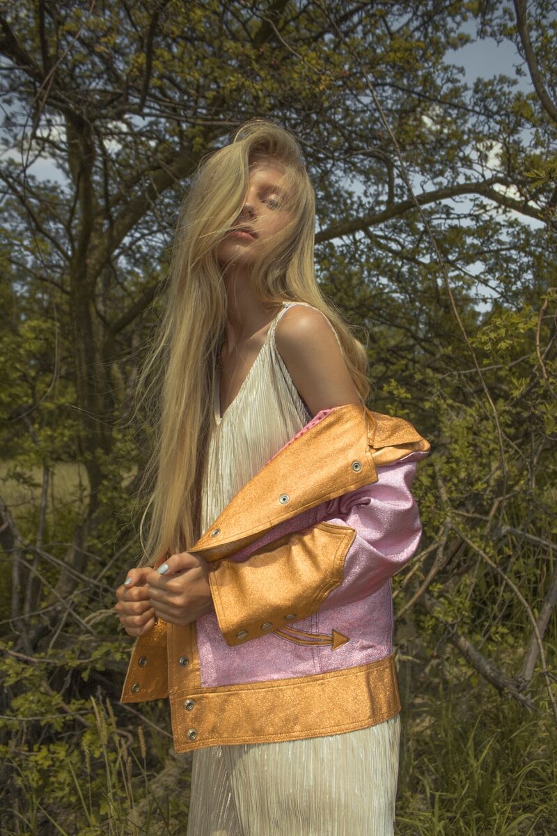 Blonde woman in stylish jacket in nature