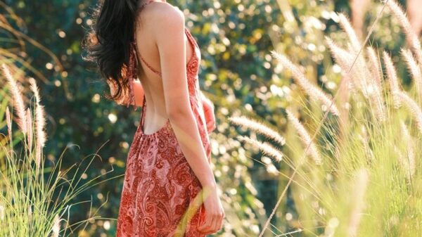 Young woman in a dress stands in tall grass