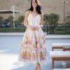 Woman in a floral sundress standing outdoors.