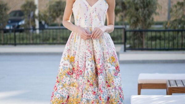 Woman in a floral sundress standing outdoors.
