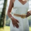 a woman in a white dress is holding a belt