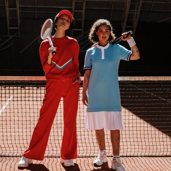 Two athletes in vibrant sport wear posing confidently on a tennis court.