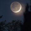 a crescent moon is seen in the night sky