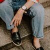 a woman sitting on steps wearing a watch