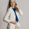 a woman in a white blazer is posing for a picture