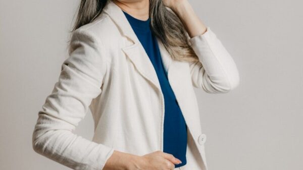 a woman in a white blazer is posing for a picture